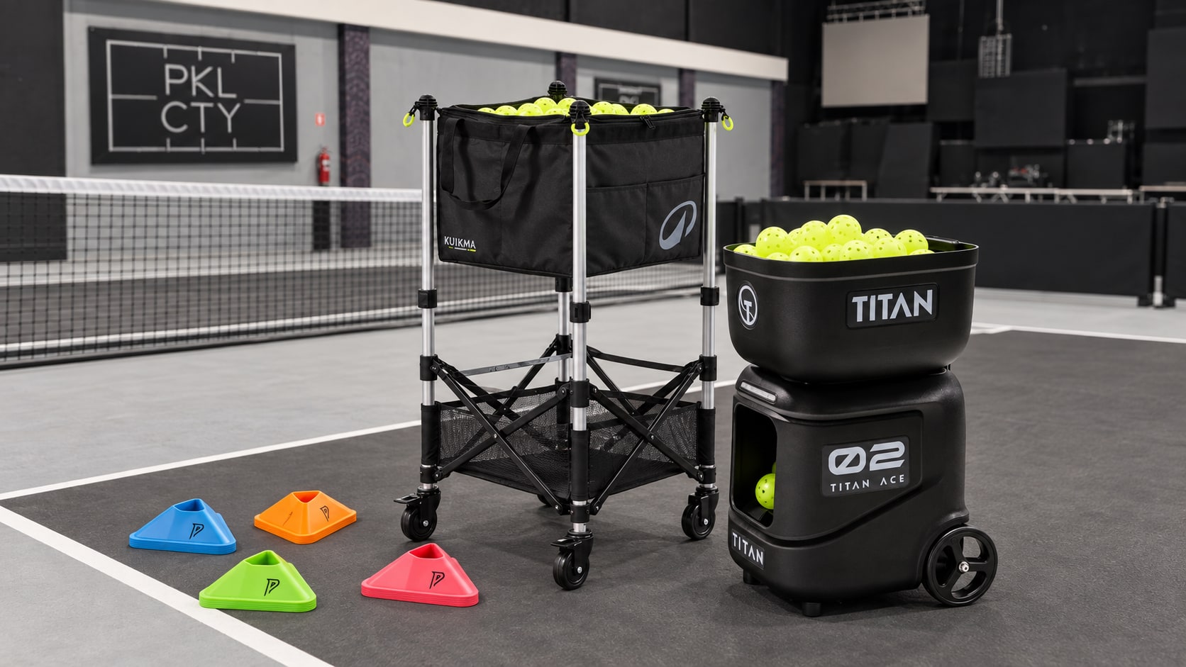 Titan ball machine, a basket of pickleballs and training cones on a PKL CTY court